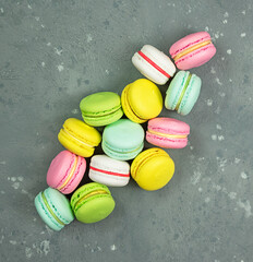 Bright pastries macarons on a gray background.