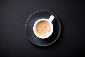 Cup of coffee on black background. Top view. Copy space.	