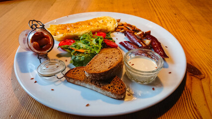 A delicious and delicious breakfast of fried eggs, sausages, champignons as well as lettuce and tomatoes