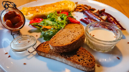 A delicious and delicious breakfast of fried eggs, sausages, champignons as well as lettuce and tomatoes