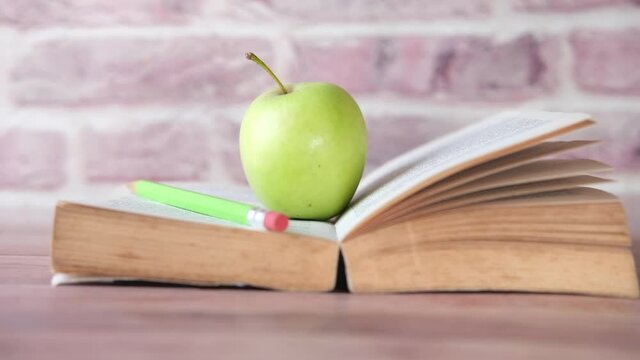 black to school concept with apple on a open book on table 