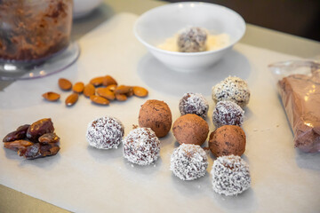 Handmade coconut snow balls made from dates, almond and coconut truffles on grey surface, healthy eating cocept
