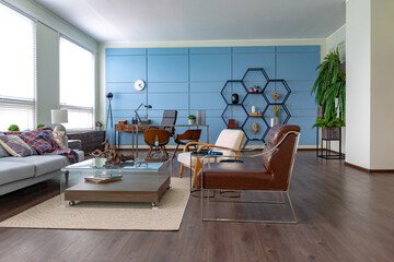 Modern trendy creative design of a personal studio office with a seating area in the style of minimalism in blue and beige colors with large windows and daylight