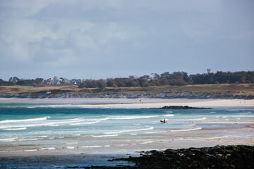 A windsurfer enjoying the beautiful scenery of the coast of Ploudalmezeau, Finistere, Bretagne, France