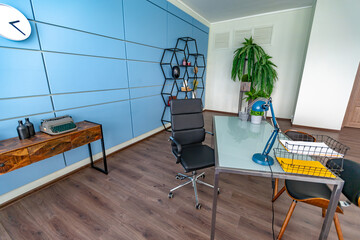Modern trendy creative design of a personal studio office with a seating area in the style of minimalism in blue and beige colors with large windows and daylight