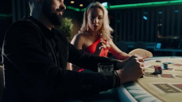 People playing poker in casino. Bearded man is winning and rejoice