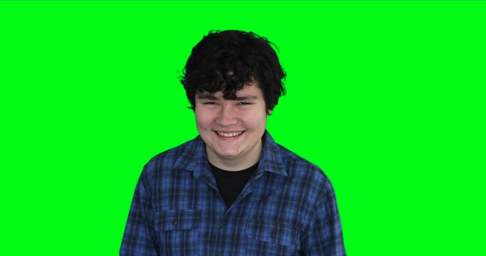 Happy teenager with pimples on face smiling to camera at green screen background
