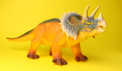 toy dinosaur close-up on a yellow background selective focus, childrens toys.