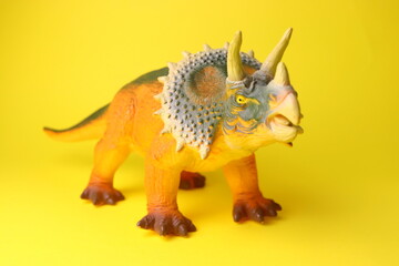 toy dinosaur close-up on a yellow background selective focus, childrens toys.