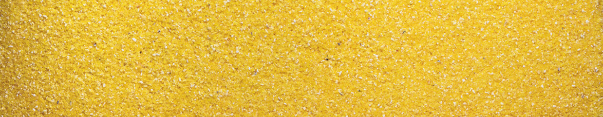 Corn grits panoramic background. Top view Close-up of corn grits texture.
