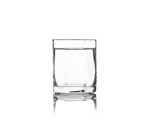 Glass tumbler with edges filled with water isolated on white background with reflection