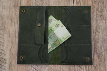 20 hryvnia in a woman's wallet on a wooden background.