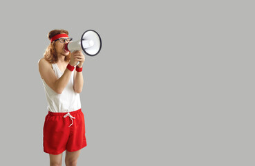 Funny noisy crazy nerdy man in sports shorts yelling in megaphone, announcing important marketing...