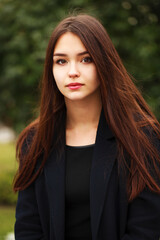 Young beautiful brunette girl in the autumn park