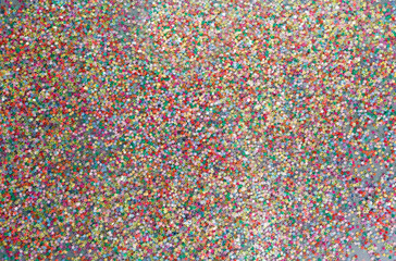 multicolored confetti on a gray background top view.