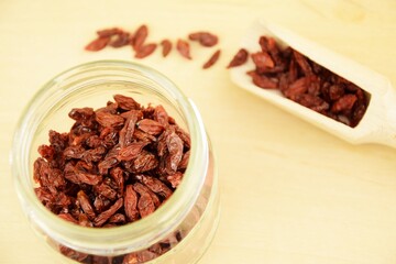 Dried goji berries on jar,  wooden background, super food, organic healthy fruits
