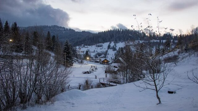 Slavs ke, Ukraine. View of ski resort Slavske in Ukraine at sunset in winter. Time-lapse of houses with mountains at the background,