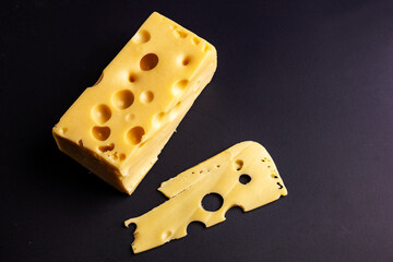 Maasdam cheese on black background.