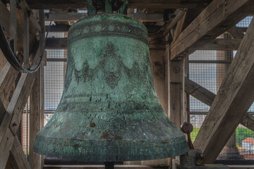 Fototapeta premium Big and massive bronze ornate bell covered in patina in belfry or bell tower of St. Donata church in Zadar old town, Croatia