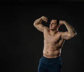 Fototapeta premium Man's biceps shows bare torso Young male business model, attractive guy bodybuilder. Men boy success single background black bodybuilder