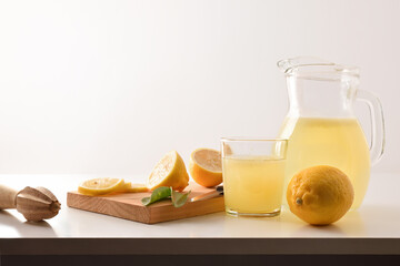 Jug and glass with freshly squeezed lemon juice isolated white