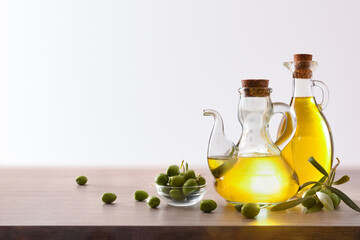 Olive oil in containers and harvest olives on bench isolated