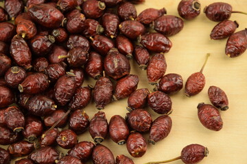 Rose hips, dried wild rose fruits on jar, natural wooden background, super food, healthy fruits, vitamin C and antioxidants resource
