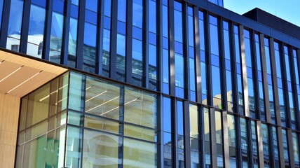 Glass facade of the buildings with a blue sky. Skyscrapers in the business city center.. Background of modern glass buildings. 