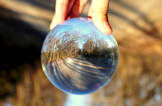 The View Of Empty Road With Dead Trees Captured Through A Crystal Lens Ball Near Chesapeake City, Maryland, U.S