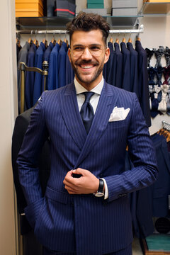 Portrait of smiling man in blue pinstripe suit in tailors boutique