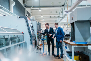 Male professionals operating manufacturing equipment in industry