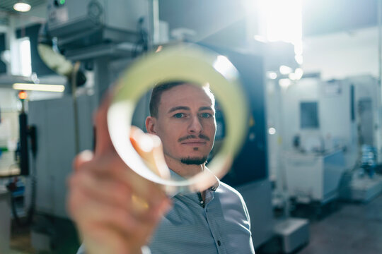 Mid adult businessman seen through circular equipment in factory