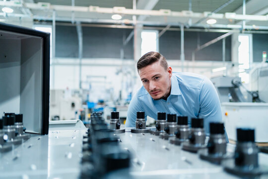 Male professional examining machine in industry