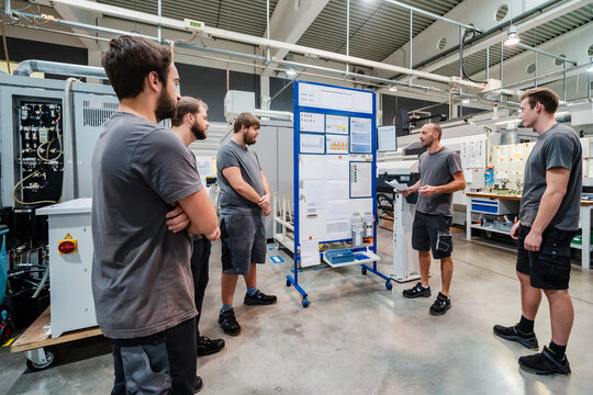 Maintenance worker having discussion while standing at industry