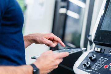 Engineer using digital tablet by machinery equipment in factory