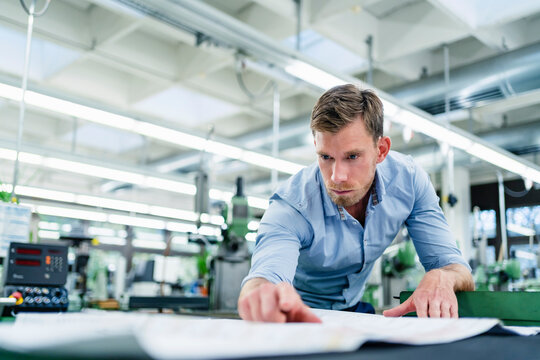 Male engineer looking over floor plan in industry