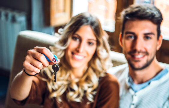 Cheerful couple holding keys from new apartment