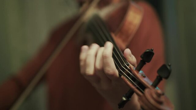 Close view of fast playing on the violin by young girl during rehearse in a hall