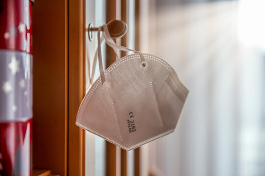 Close-up of face mask hanging on knob at home