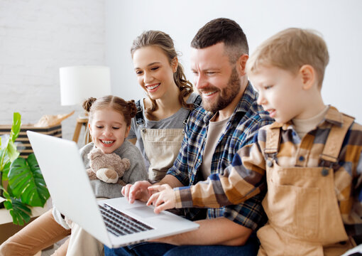 Cheerful family using laptop during relocation in new apartment