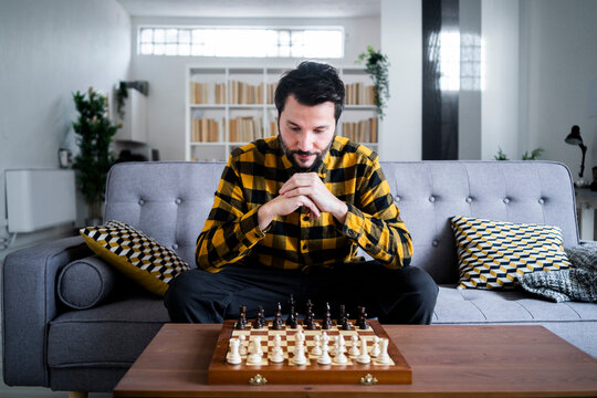 Man sitting on sofa in front of chess board