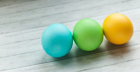 Colored Easter eggs on a light wooden background.