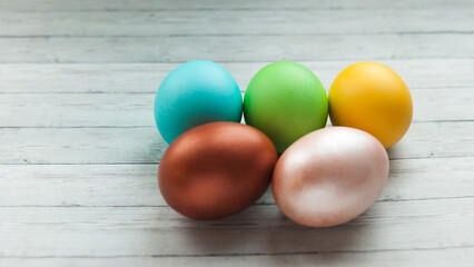 Colored Easter eggs on a light wooden background.