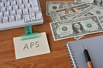 On the desk there were bills, a keyboard, and a word book with the word average propensity to save written on it.