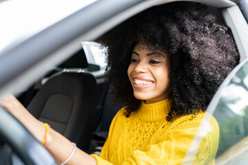 Curly hair woman smiling while driving car