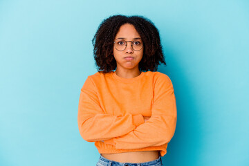 Obraz premium Young african american mixed race woman isolated blows cheeks, has tired expression. Facial expression concept.