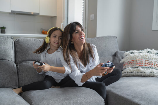 Mother and daughter playing together at the console in their joint custody week, Spain