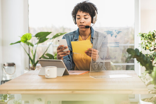 Woman with headset working at desk at home