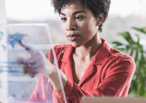 Woman pointing at transparent display at home