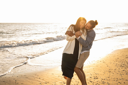 Cheerful couple enjoying at beach during sunny day